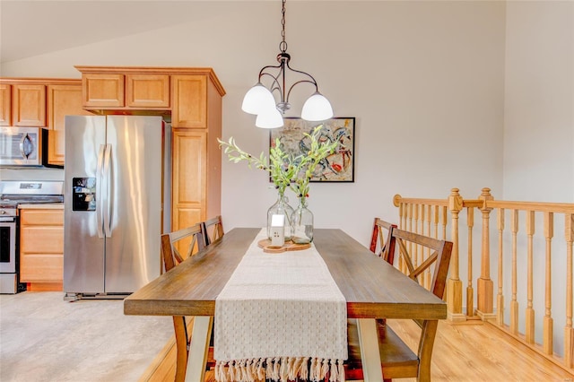 dining space featuring vaulted ceiling and a chandelier