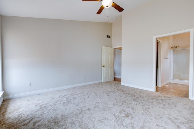 unfurnished bedroom with baseboards, carpet floors, visible vents, and high vaulted ceiling