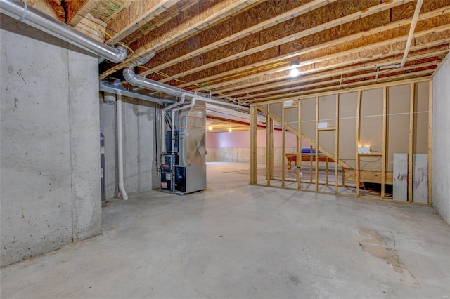 unfinished below grade area featuring heating unit and electric water heater