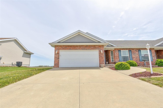 ranch-style house featuring brick siding, central air condition unit, driveway, and an attached garage