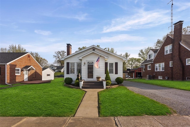 bungalow-style home featuring central air condition unit, a chimney, and a front yard