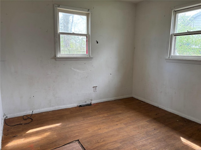 empty room featuring baseboards and wood finished floors