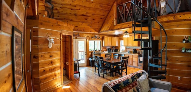dining area with wooden walls, light wood-type flooring, high vaulted ceiling, and wooden ceiling
