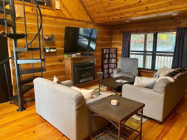 living room with wooden ceiling, wood finished floors, vaulted ceiling, wood walls, and a fireplace