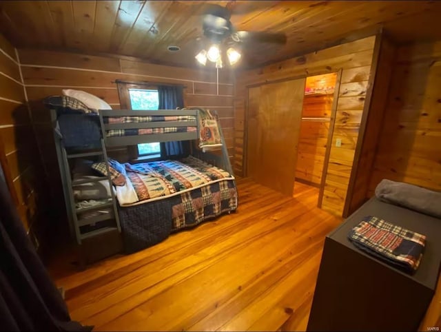 bedroom featuring wooden ceiling, wood finished floors, and wood walls