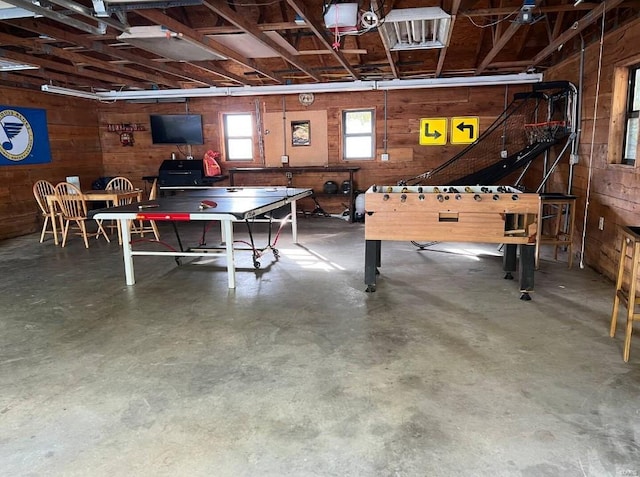 playroom with wooden walls and concrete floors