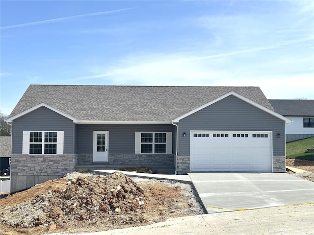 ranch-style house featuring a garage, roof with shingles, concrete driveway, and stone siding
