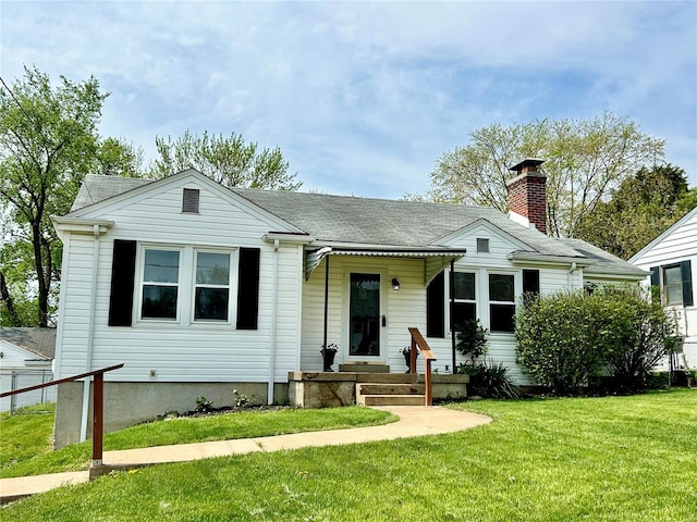 view of front of home featuring a front lawn and a shingled roof