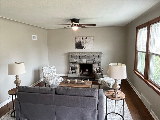 living area with wood finished floors, visible vents, ceiling fan, and a healthy amount of sunlight