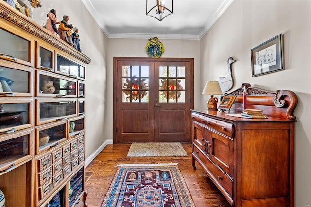 entrance foyer featuring a notable chandelier, crown molding, and dark wood-type flooring