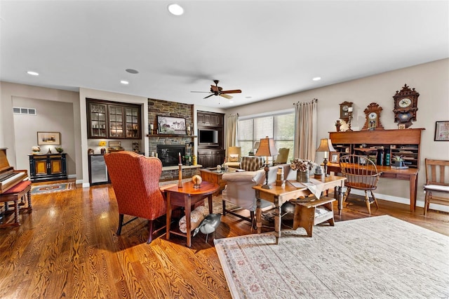 living room with recessed lighting, wood finished floors, ceiling fan, and a fireplace