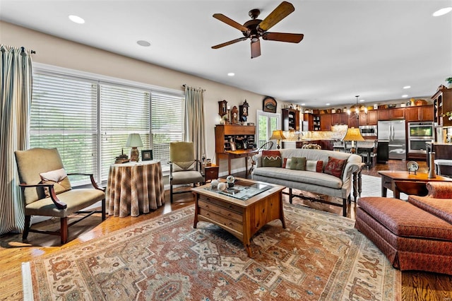 living room featuring wood finished floors, a ceiling fan, and recessed lighting