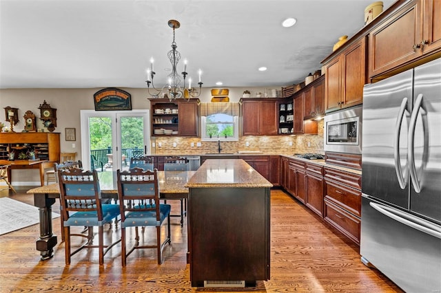 kitchen with a wealth of natural light, stainless steel appliances, open shelves, and a center island