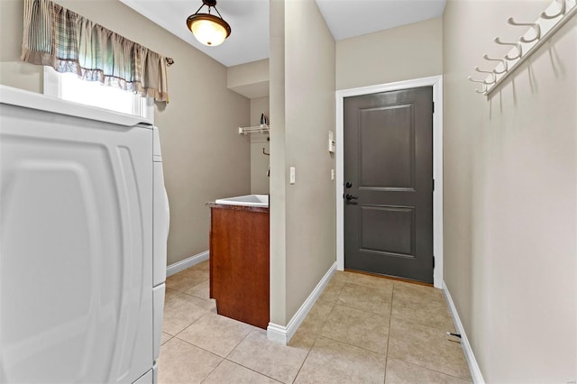 foyer with light tile patterned flooring, washer / dryer, and baseboards