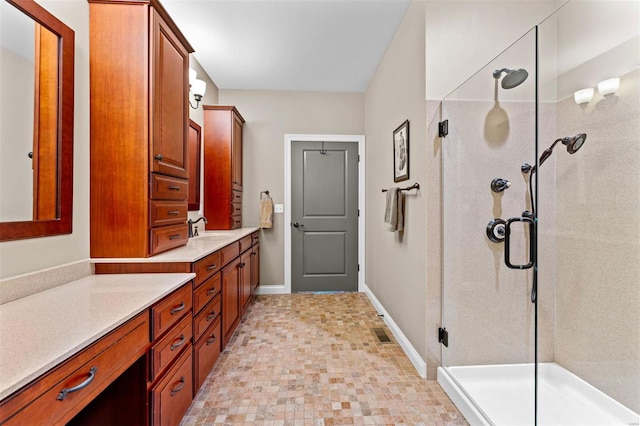 bathroom featuring baseboards, visible vents, a shower stall, and vanity