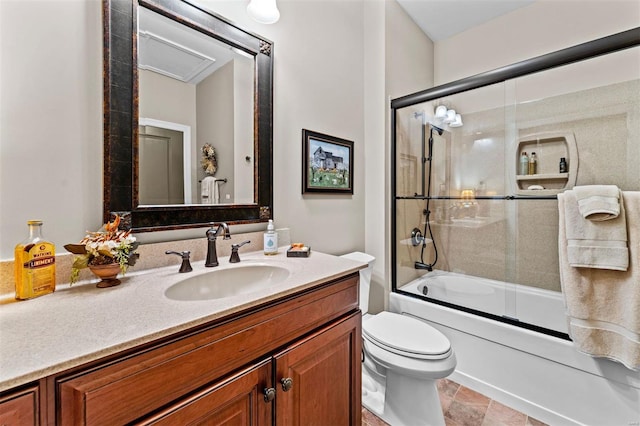 bathroom featuring toilet, vanity, combined bath / shower with glass door, and stone finish flooring
