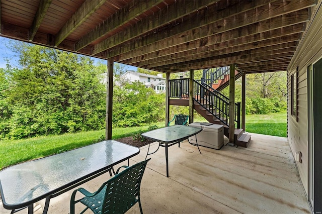 view of patio with outdoor dining space and stairs