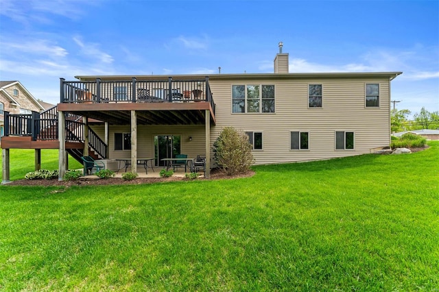 rear view of house with a lawn, a chimney, a patio area, and a wooden deck