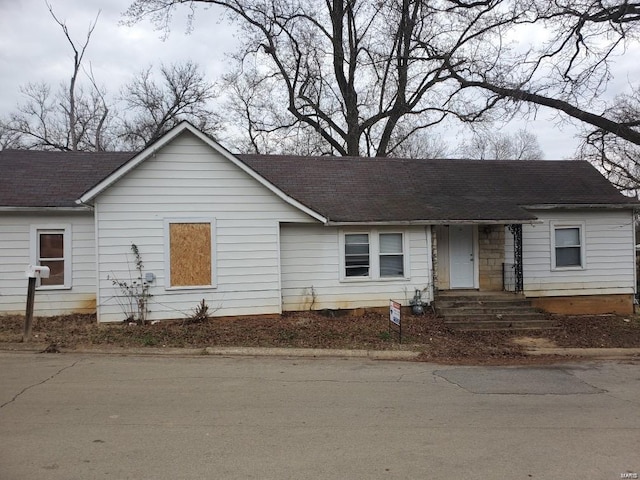 ranch-style house featuring roof with shingles