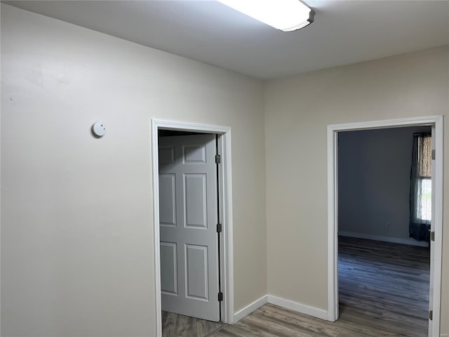 hallway with baseboards and wood finished floors
