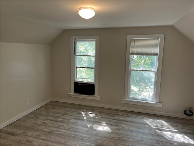 bonus room with baseboards, vaulted ceiling, and wood finished floors