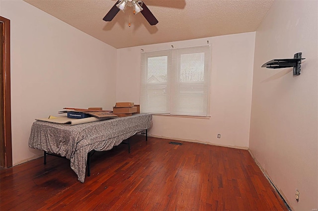 bedroom featuring wood-type flooring, a textured ceiling, and ceiling fan