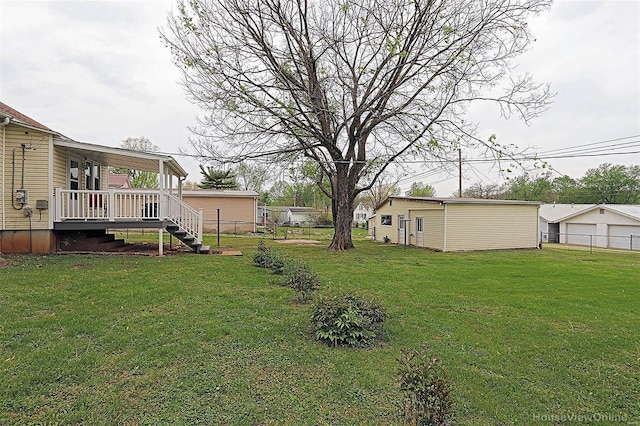 view of yard with fence, a detached garage, and stairway