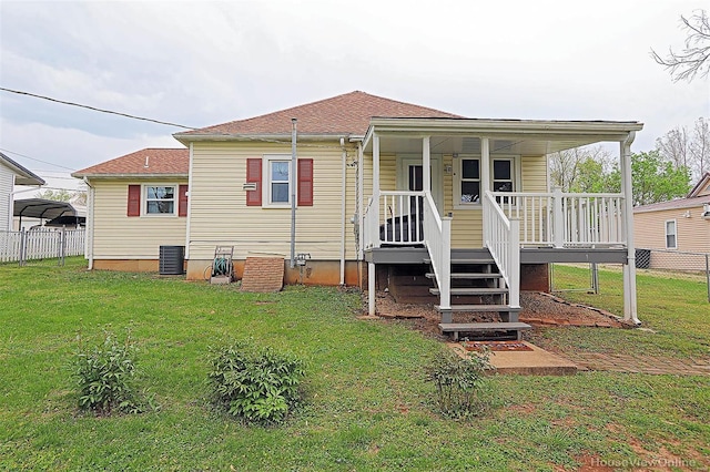 back of property with fence, a lawn, a porch, and cooling unit