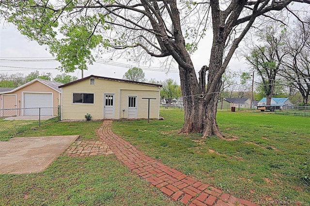 view of yard featuring a garage, fence, and an outdoor structure
