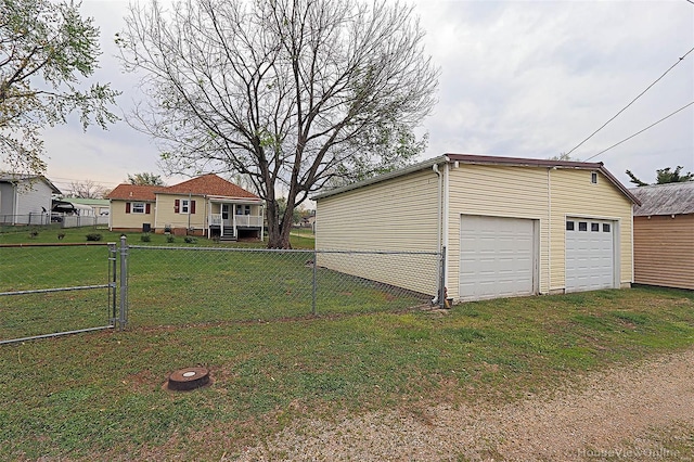 view of yard with fence, an outdoor structure, and a garage