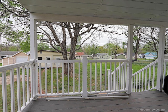 wooden deck with a lawn, an outdoor structure, a residential view, and a garage