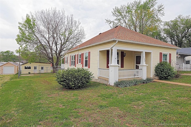 view of front facade featuring fence, a front yard, and covered porch