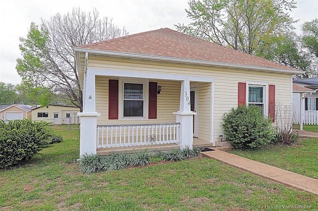 bungalow-style home featuring covered porch and a front yard
