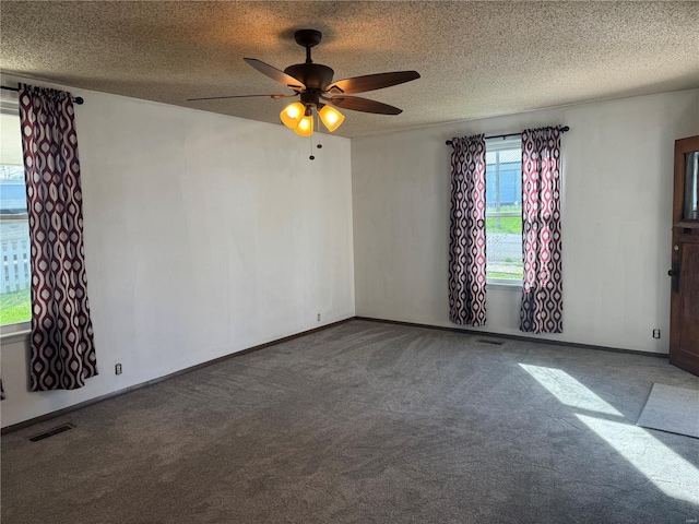 unfurnished room with carpet floors, a ceiling fan, a textured ceiling, and visible vents