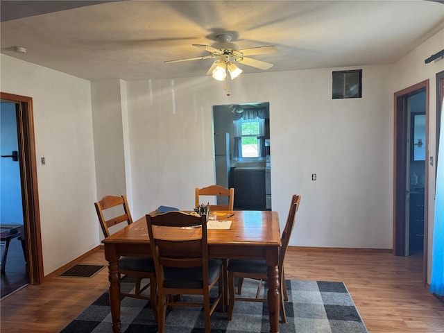 dining area featuring ceiling fan, baseboards, wood finished floors, and visible vents