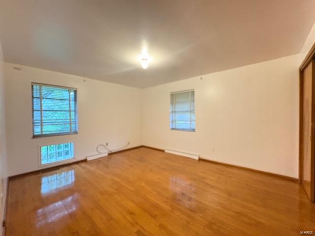 spare room featuring baseboards and wood finished floors