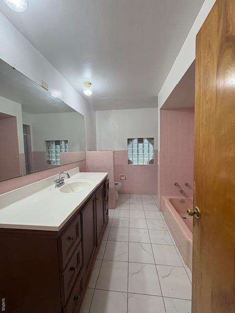 full bathroom featuring marble finish floor, vanity, toilet, and a bathtub