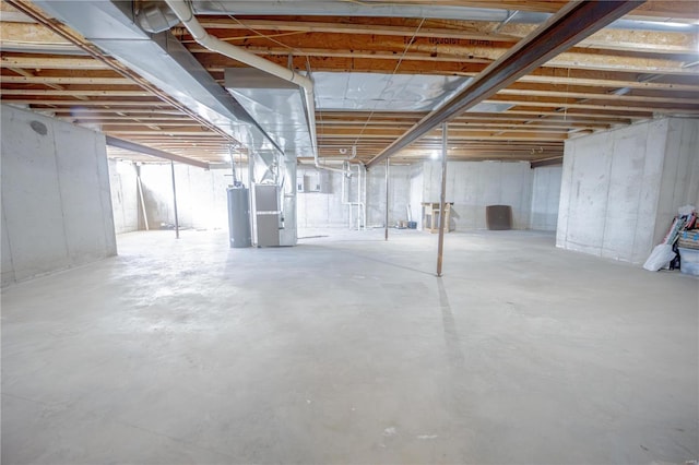 unfinished below grade area featuring heating unit and water heater