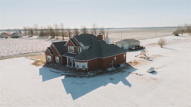 rear view of property featuring an outdoor structure, a rural view, and a chimney