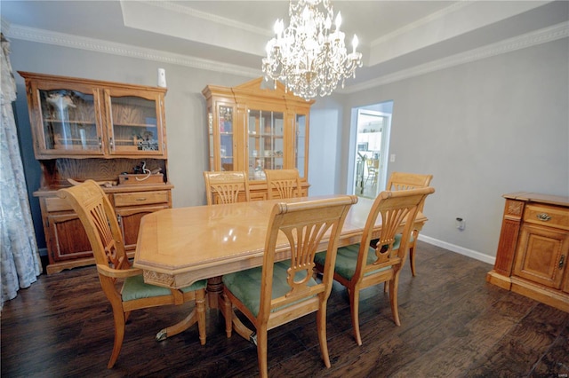 dining room featuring a chandelier, a tray ceiling, and dark wood finished floors