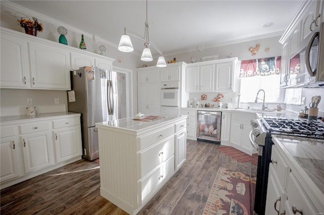 kitchen with stainless steel appliances, a kitchen island, white cabinets, and a sink