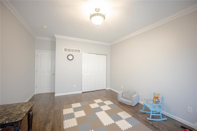 interior space with wood finished floors, visible vents, crown molding, and baseboards