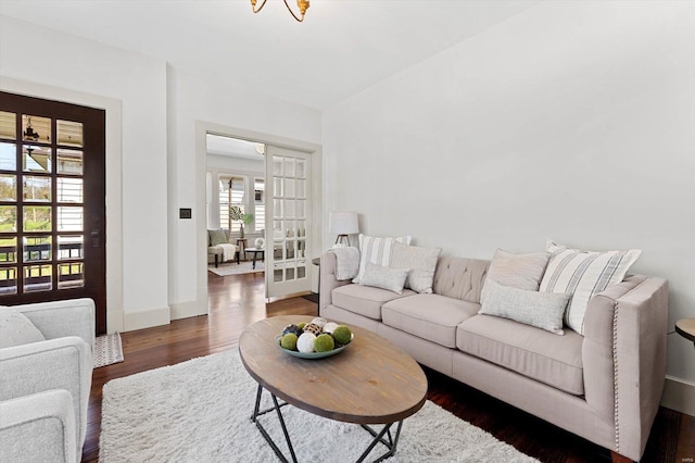 living area with baseboards and wood finished floors