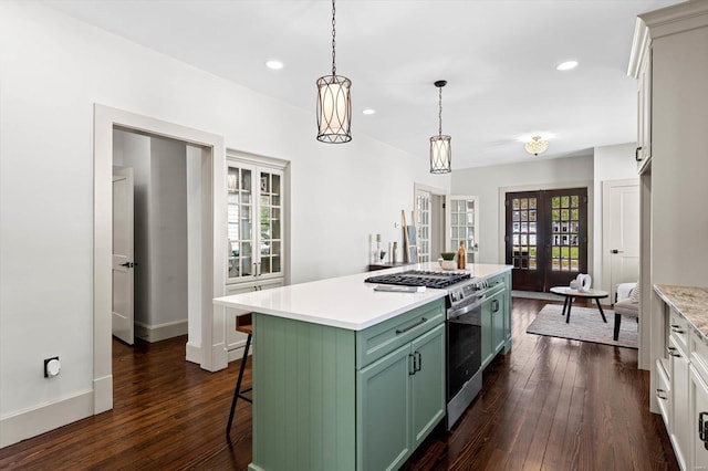 kitchen featuring stainless steel range with gas cooktop, french doors, light countertops, green cabinetry, and dark wood-type flooring