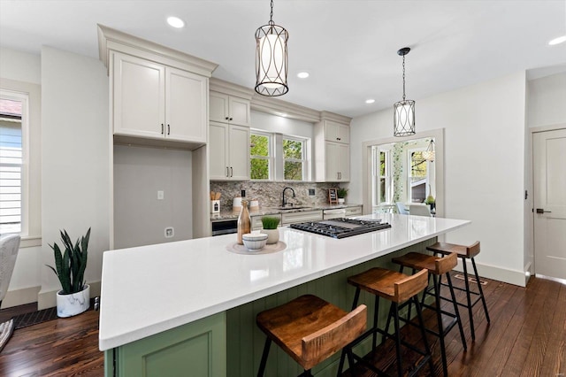 kitchen with light countertops, tasteful backsplash, dark wood-style floors, and recessed lighting