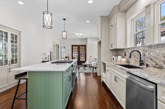 kitchen featuring a sink, decorative backsplash, stainless steel appliances, dark wood-type flooring, and recessed lighting