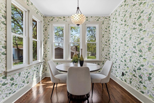 dining area featuring dark wood finished floors, wallpapered walls, and baseboards