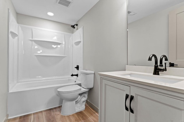 bathroom featuring bathing tub / shower combination, toilet, visible vents, wood finished floors, and vanity