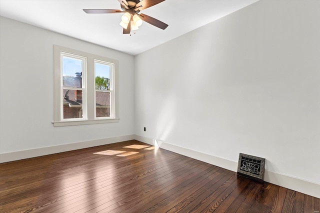 spare room featuring ceiling fan, baseboards, dark wood-style flooring, and visible vents