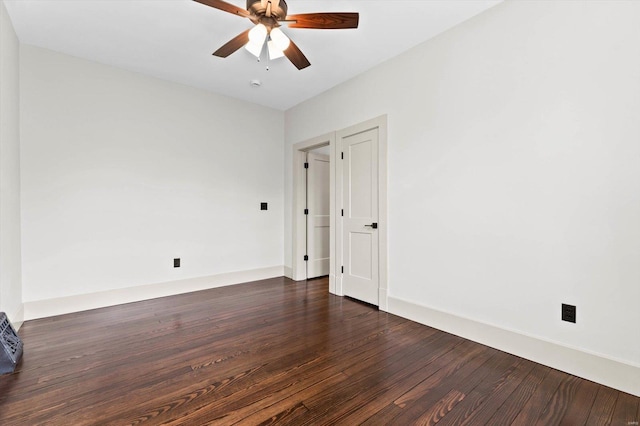 spare room featuring dark wood-type flooring and a ceiling fan